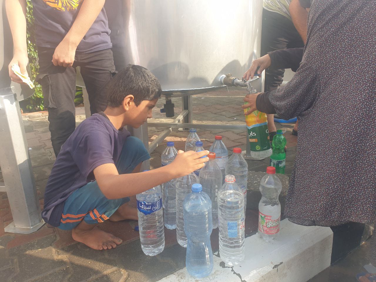 أطفال ونساء يتوافدون إلى محطة تحلية المياه في رفح جنوب قطاع غزة، لتعبئة الحد الأدنى من احتياجاتهم في ظل قطع الاحتلال إمدادات المياه عن القطاع. ومحطة تحلية المياه هذه مهددة بالتوقف عن العمل في أي لحظة بسبب أزمة الوقود